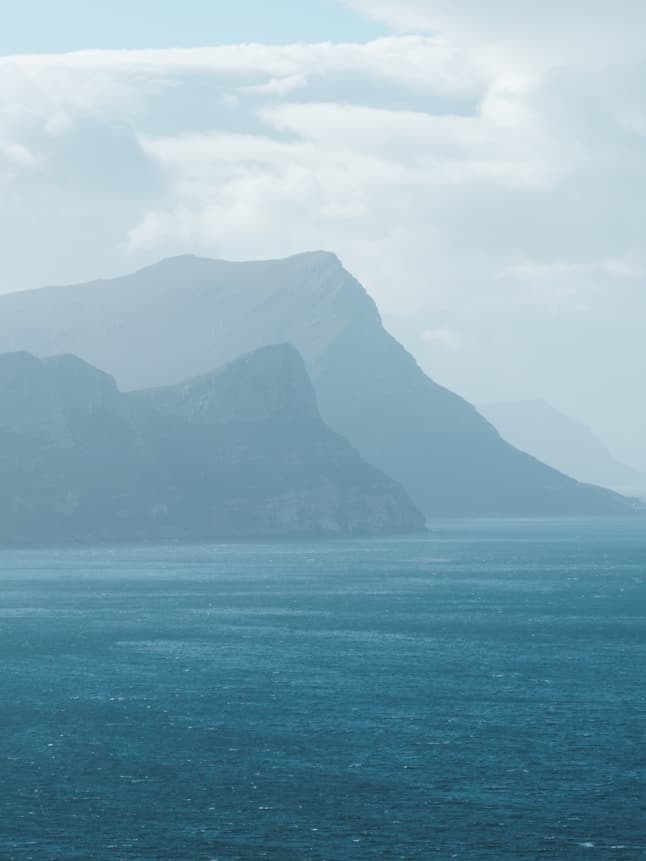 Hazy headlands of the Cape Peninsula rising from False Bay, in soft blue-grey light